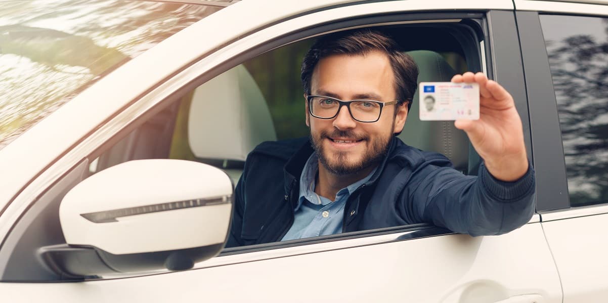Homem dentro do carro mostrando sua cnh social