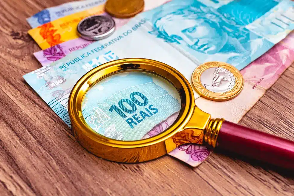 Lupa na nota de 100 mostrando os valores atrasados do INSS