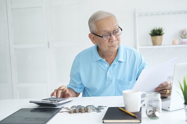 idoso analisando descontos em seus benefícios do inss e usando a calculadora 