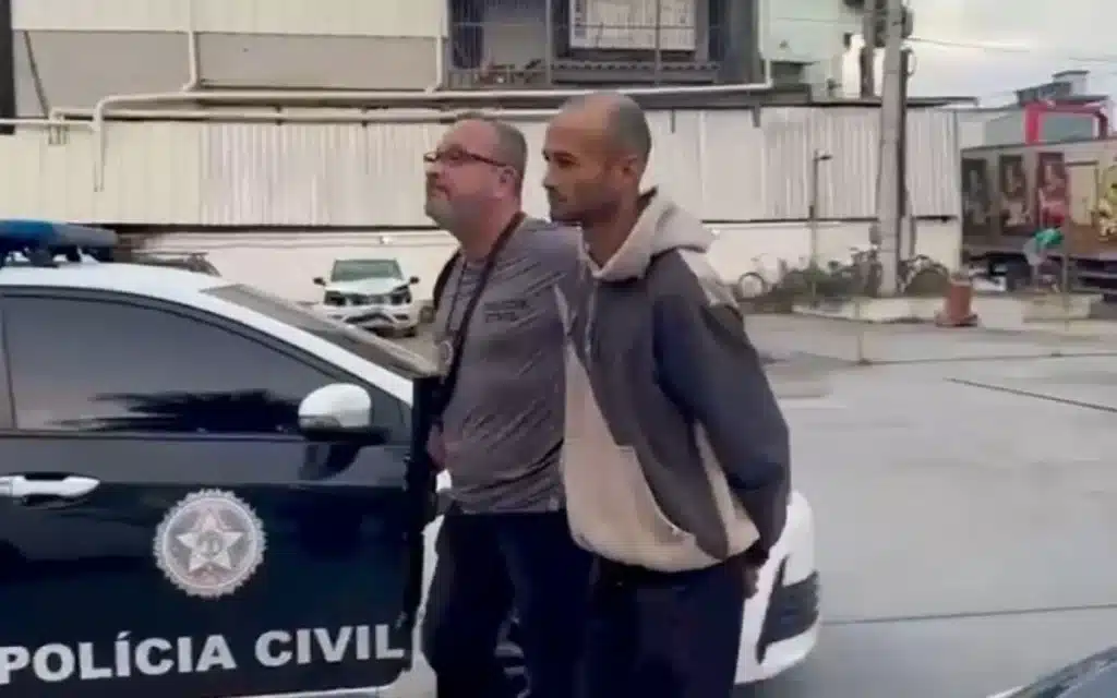 Policial Civil levando homem algemado para a cadeia