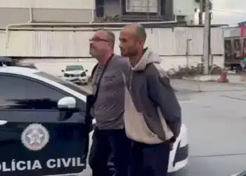 Policial Civil levando homem algemado para a cadeia