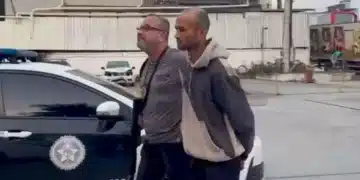 Policial Civil levando homem algemado para a cadeia