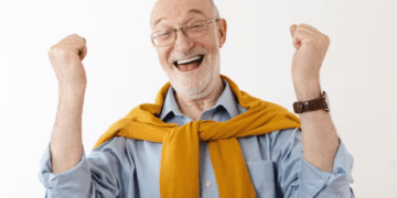 homem idoso feliz levantando os punhos cerrados em sinal de comemoração
