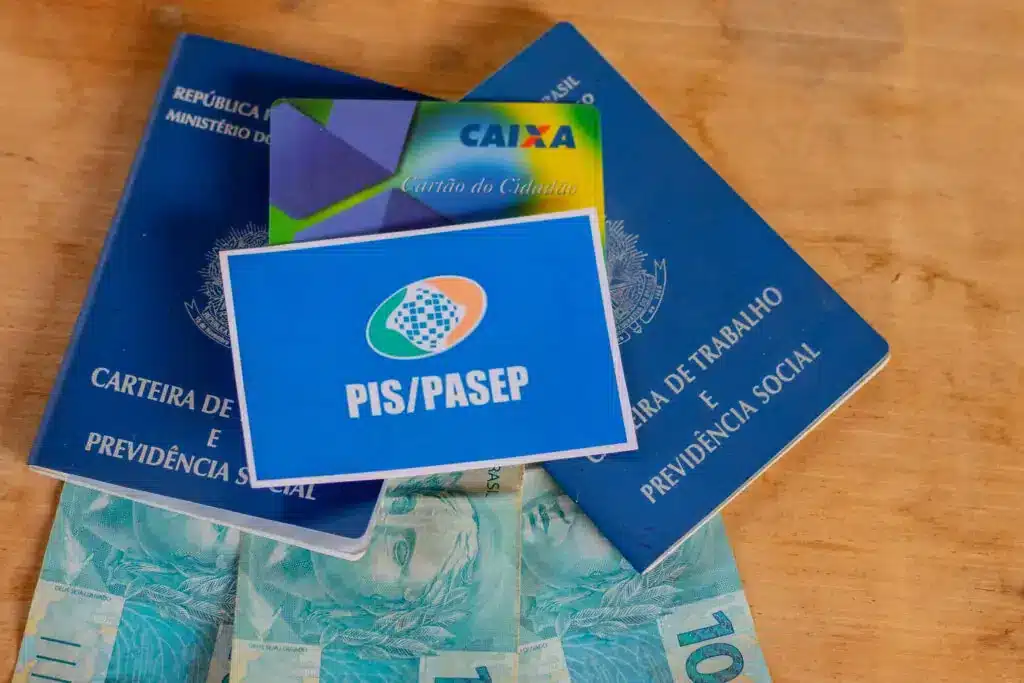 cartao do pis pasep, carteira de trabalho e notas de 100 reais