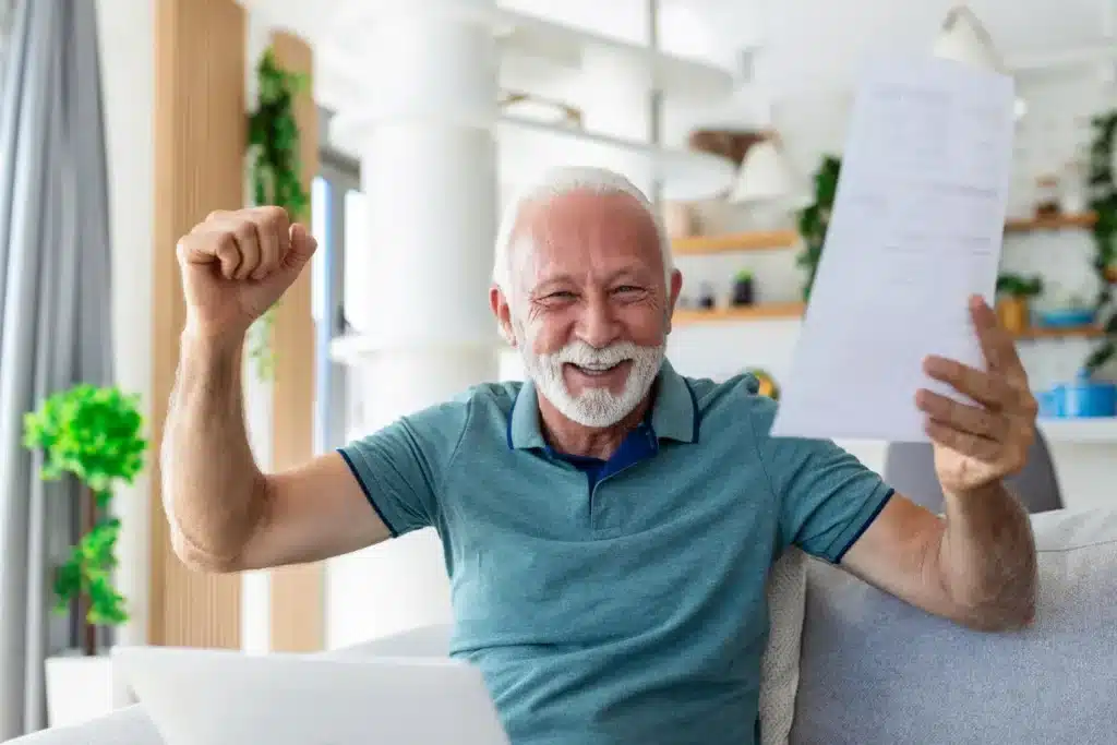 Senhor aposentado comemora com contracheque na mão. 