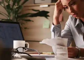 empresária no seu escritório, sentada e mexendo no computador