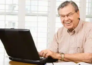 aposentado do inss sentado em frente ao computados pesquisando como cancelar o consignado do inss