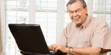 aposentado do inss sentado em frente ao computados pesquisando como cancelar o consignado do inss