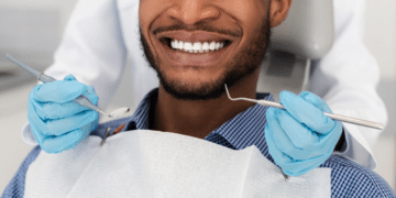 Homem negro sorridente no dentista