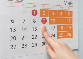 Mão apontando para calendário de maio