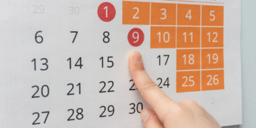 Mão apontando para calendário de maio