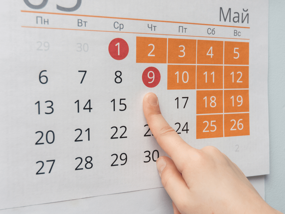Mão apontando para calendário de maio