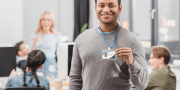 Rapaz segura crachá de emprego