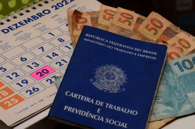 Calendário, carteira de trabalho e notas de dinheiro