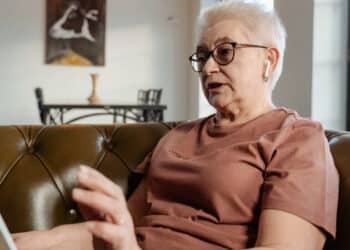 idosa sentada, lendo sobre a mudança na aposentadoria para quem nasceu de 1964 a 1969