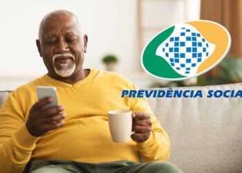 aposentado do inss sentado no sofá com uma xícara e celular na mão