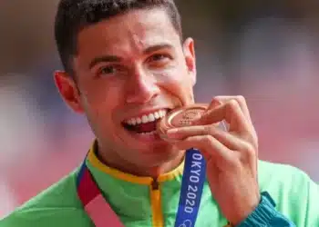 Atleta Thiago Braz mordendo medalha de bronze