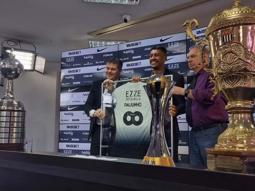 Jogador Paulinho segurando camisa do Corinthians
