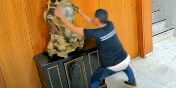 Foto do homem derrubando o relógio (Fonte: Reprodução/Agência Brasil)