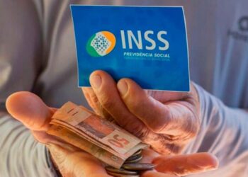 imagem de um senhor segurando o cartão do inss com dinheiro para falar do revisão da vida toda