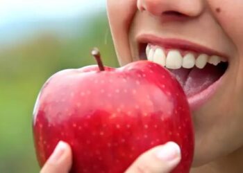 Pessoa comendo maçã (Fonte: Reprodução/Shutterstock)