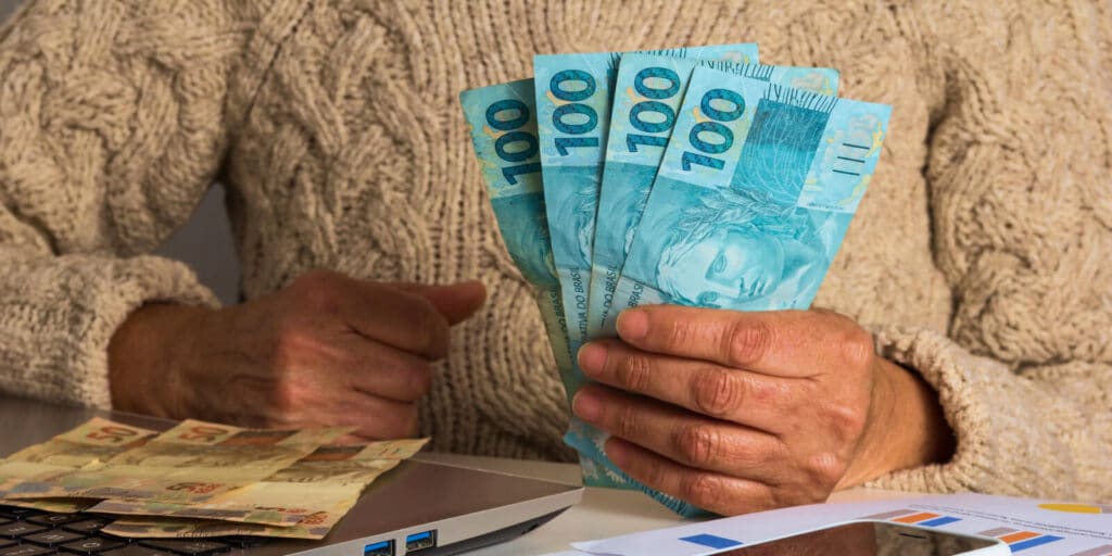 imagem de uma pessoa que recebe dinheiro do BPC e Bolsa Família: benefícios podem ultrapassar R$ 2.000 por mês!