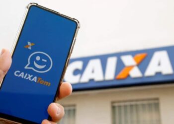 imagem de uma pessoa segurando o celular com o app da Caixa Tem
