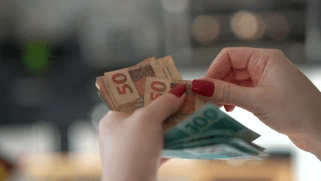 pessoa contando cédulas de dinheiro