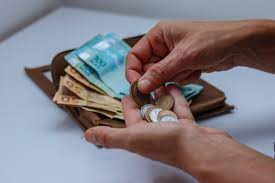 imagem de uma pessoa contando o dinheiro para falar sobre o futuro dos benefícios sociais