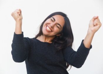 mulher feliz, comemorando com os punhos cerrados para cima.