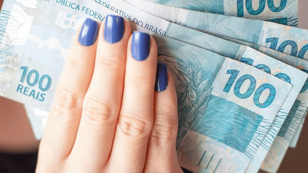 pessoa segurando cédulas de dinheiro