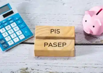 dois blocos de madeira com inscrições 'pis' e 'pasep' em cada um. os blocos estão entre uma calculadora azum e um cofre de porquinho rosa.