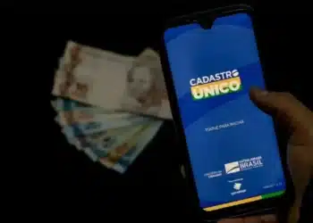 cédulas de dinheiro e um celular com cadastro único de papel de parede