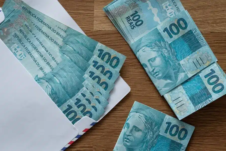Novo aumento do salário mínimo. em cédulas de 100 reais (Fonte: shutterstock).