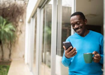 Beneficiário do INSS verificando pagamento do 13º salário no celular. (Fonte iStock).