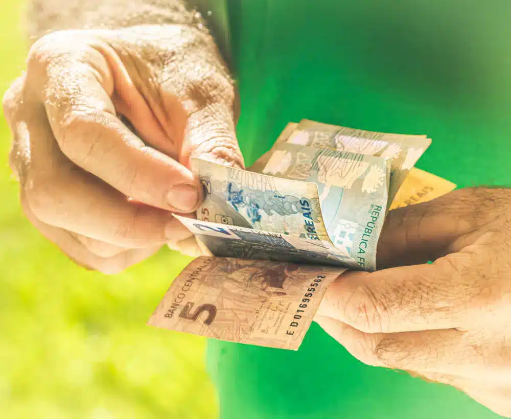 Aposentado segurando bônus de 200 reais do programa Voa Brasil. (Fonte: shutterstock).