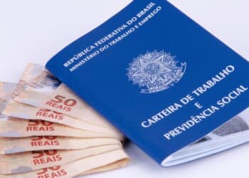 carteira assinada ao lado de notas de 50 reais