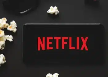 tv ligada na netflix ao lado de um balde de pipoca