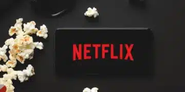 tv ligada na netflix ao lado de um balde de pipoca
