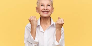 idosa feliz em frente a um fundo amarelo