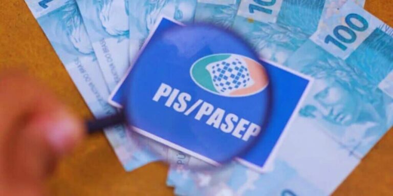 pagamento do pis pasep em notas de 100 reais, com uma lupa em cima do cartão pis pasep