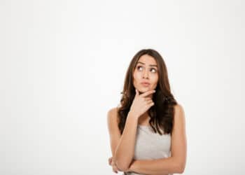 mulher com a mão sobre o queixo, com cara de dúvida (Fonte: Reprodução Freepik)