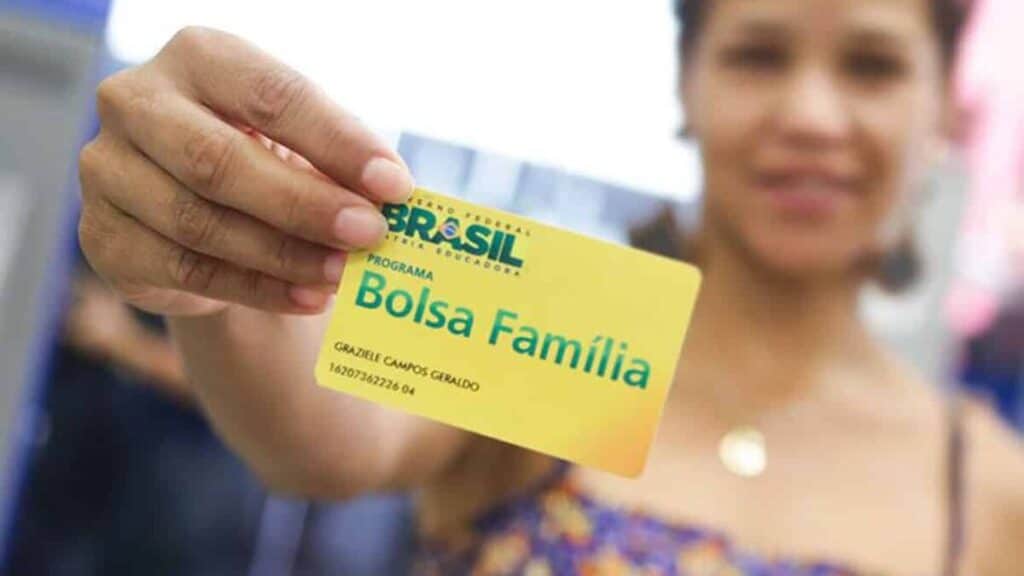 mulher segurando cartão do bolsa família