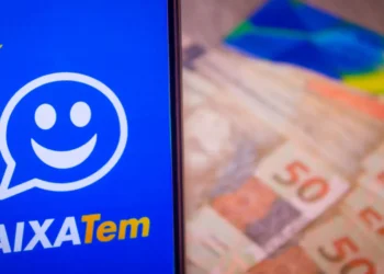 celular aberto no caixa tem ao lado de cédulas de 50 reais