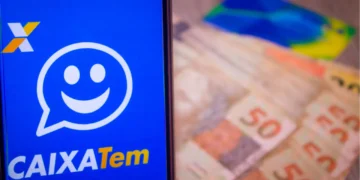 celular aberto no caixa tem ao lado de cédulas de 50 reais