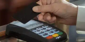 mão da pessoa passando o cartão de crédito na maquininha