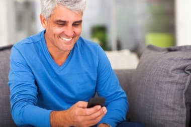 idoso no celular comemora aumento do salário mínimo