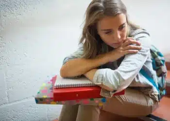 Estudante triste com o atraso do pagamento do benefício pé de meia. (Fonte depositphotos).