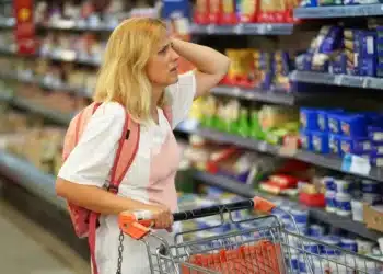 Mulher no mercado horrorizada com o aumento de preço do gás de cozinha e outros produtos. (Fonte: depositphotos).