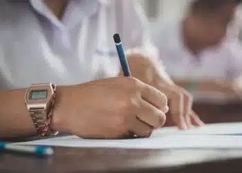 mão segurando uma caneta e marcando a prova de concurso